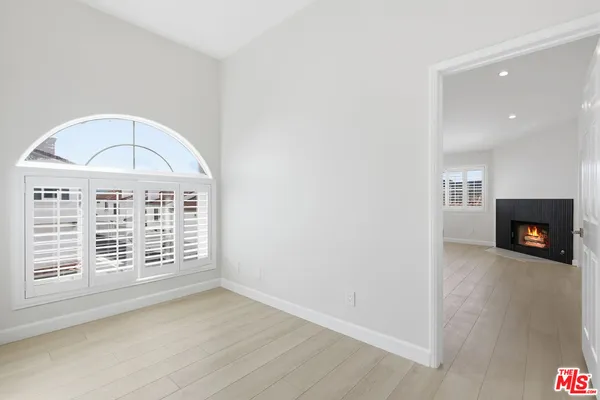 an empty room with windows and fireplace