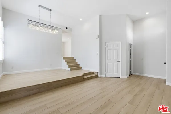 a view of a room with wooden floor and white walls