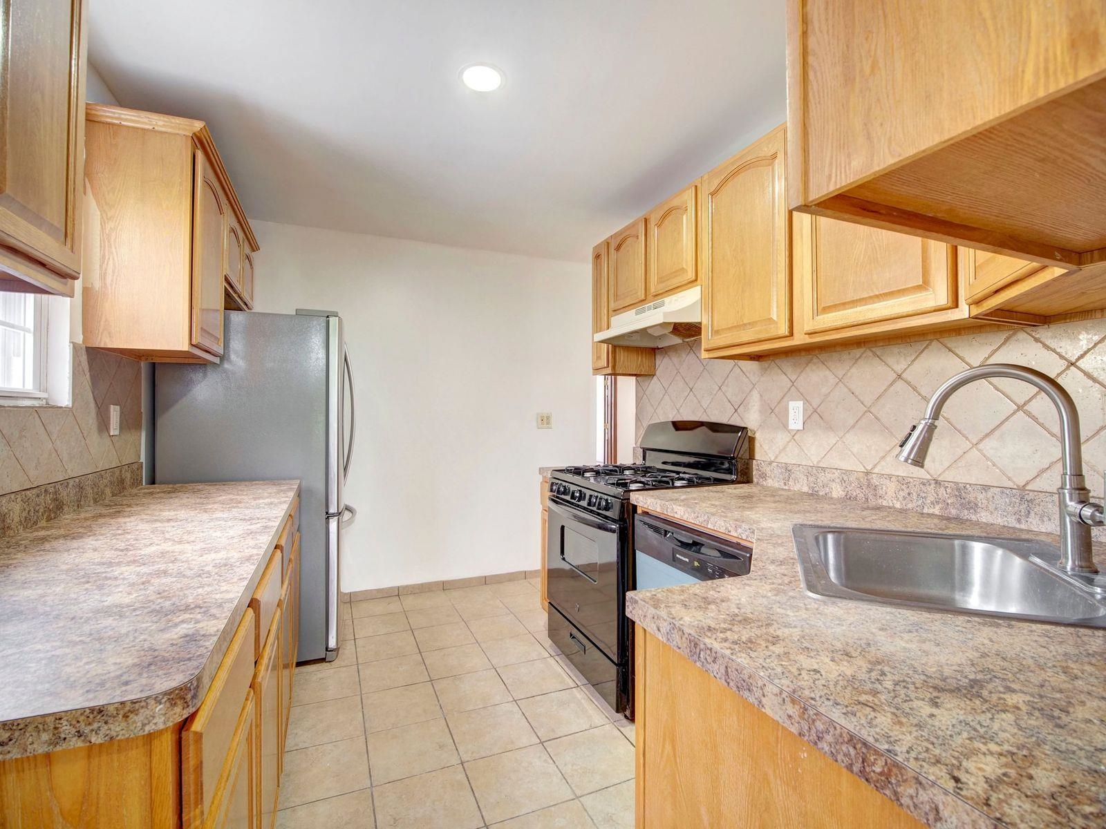 921 Paterson Plank Road, Unit 2 North Bergen, NJ 07047 - Photo 14 of 15 a kitchen with stainless steel appliances granite countertop a sink stove and refrigerator