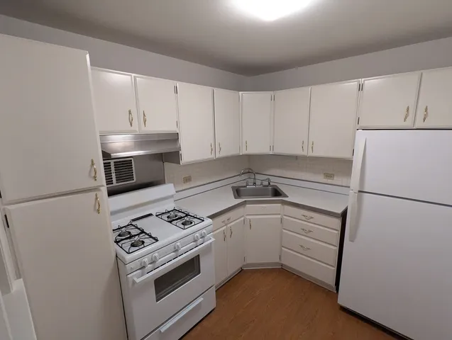 a kitchen with white cabinets and white appliances