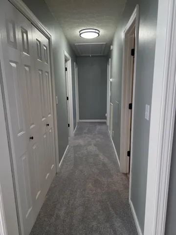 en empty room with windows and chandelier fan