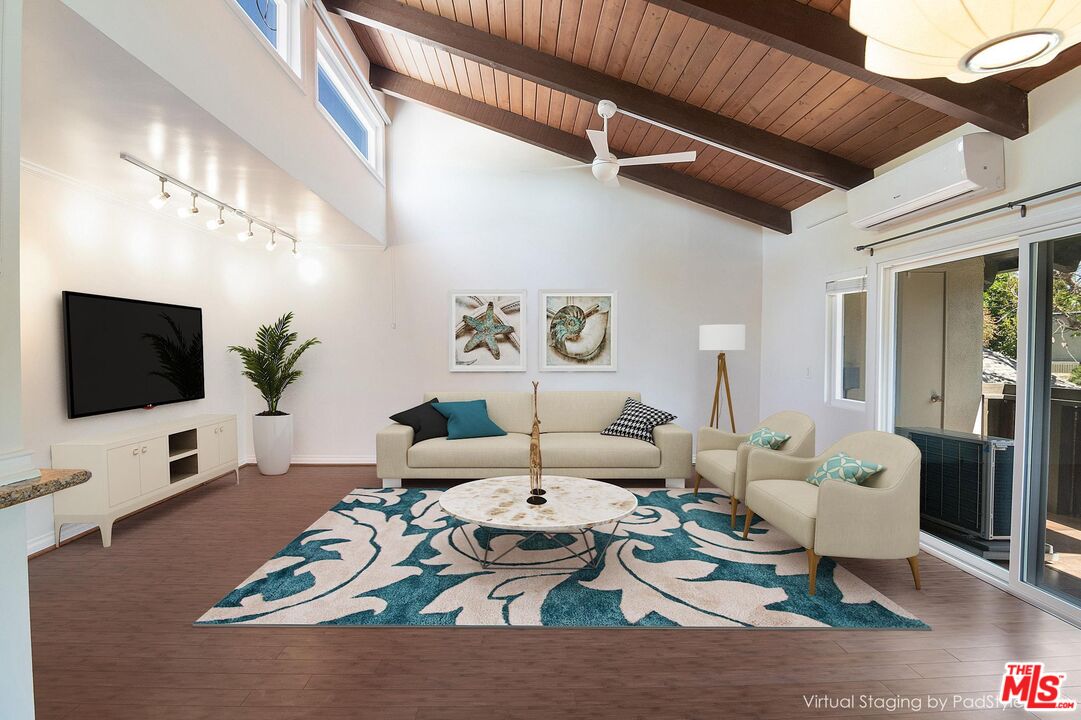 4925 Indian Wood Road, Unit 474 Culver City, CA 90230 - Photo 1 of 36 a living room with furniture a flat screen tv and a floor to ceiling window