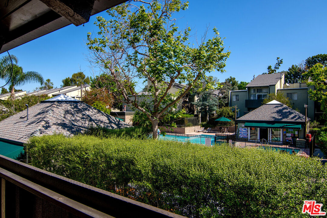 4925 Indian Wood Road, Unit 474 Culver City, CA 90230 - Photo 11 of 36 a view of a swimming pool with lawn chairs under an umbrella