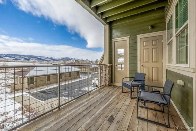 a view of a balcony with wooden floor and outdoor seating