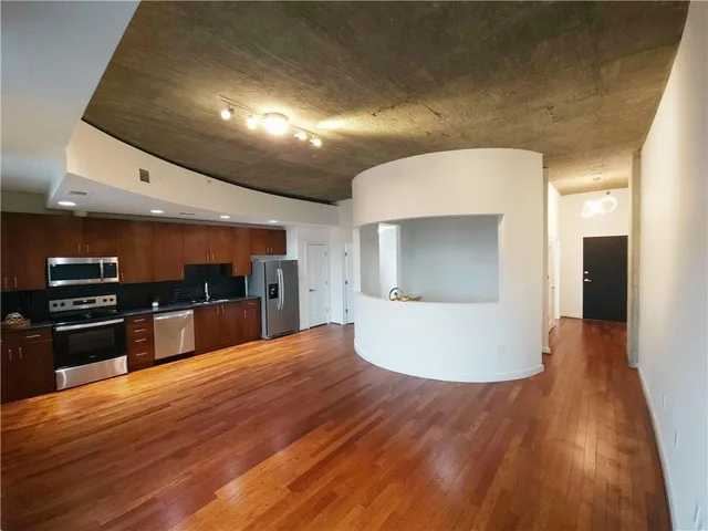 a large kitchen with stainless steel appliances a large counter top