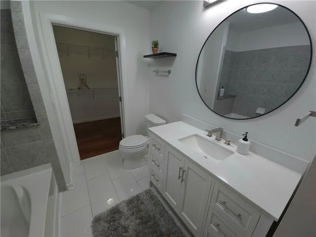 a bathroom with a sink and mirror with toilet