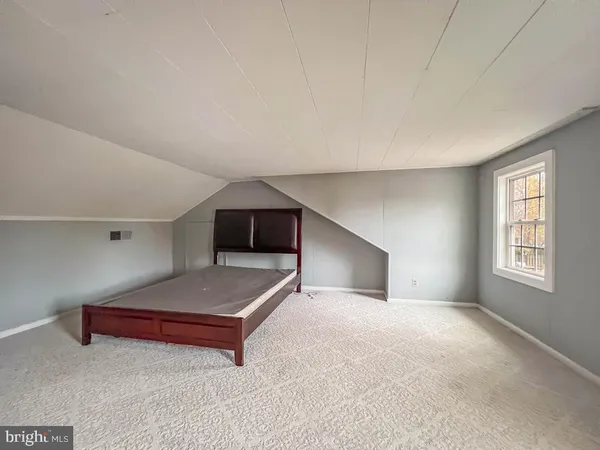 a spacious bedroom with a bed and a window