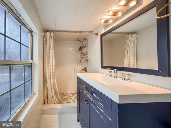a bathroom with a sink a mirror and a bathtub
