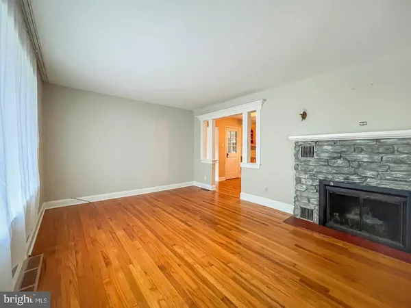 a view of empty room with wooden floor and fireplace