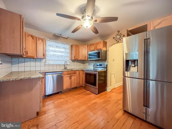 a kitchen with a refrigerator a stove top oven a sink and dishwasher with wooden floor