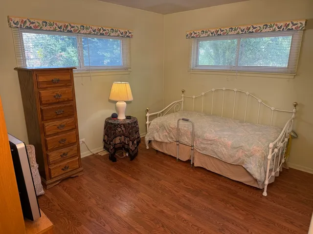a bedroom with a bed and wooden floor