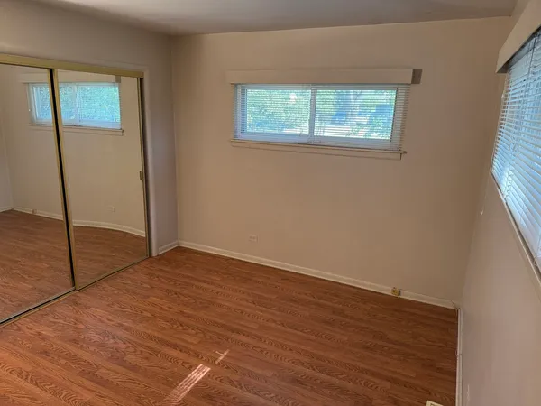 a view of an empty room with window and closet area