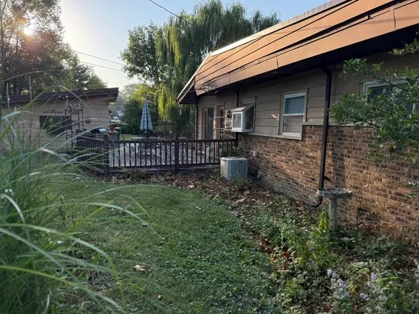 a view of backyard of house with wooden deck and entertaining space