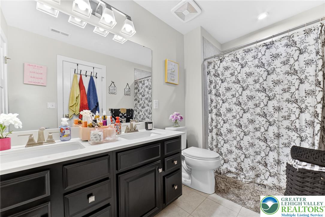 3952 Orth Street Bethlehem, PA 18020 - Photo 36 of 60 Double vanity with sleek dark cabinetry provides ample storage in this well-appointed bathroom.