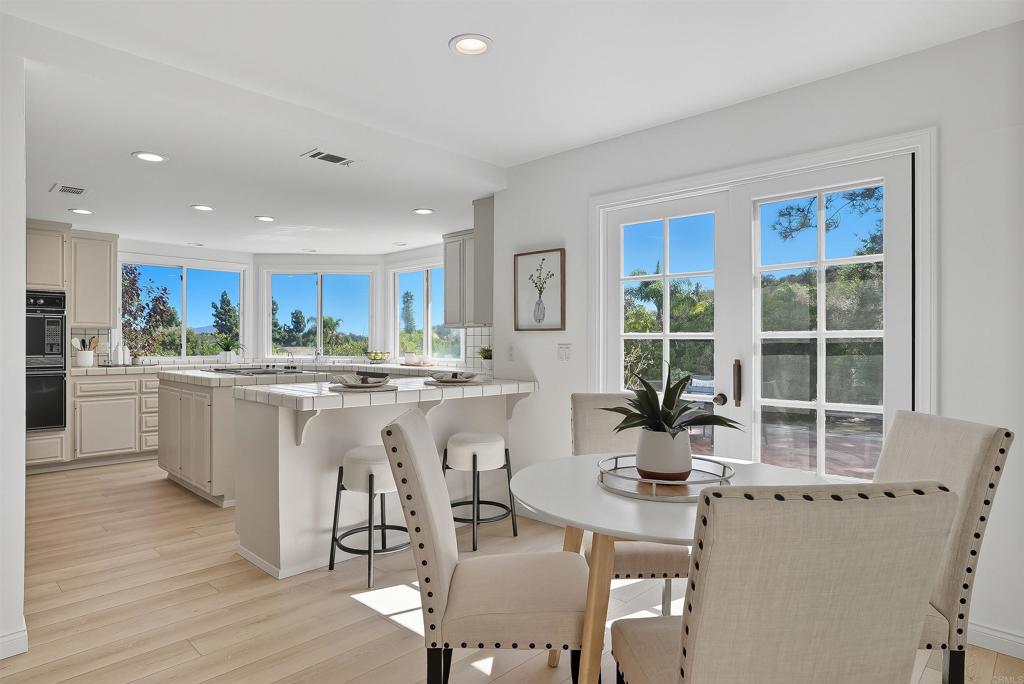 2206 Running Spring Place Encinitas, CA 92024 - Photo 16 of 44 a kitchen with a dining table chairs and wooden floor