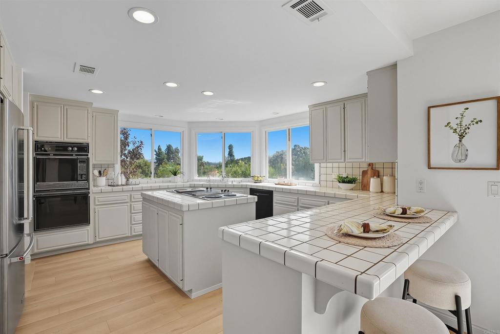 2206 Running Spring Place Encinitas, CA 92024 - Photo 18 of 44 a kitchen with a stove a refrigerator and a dining table