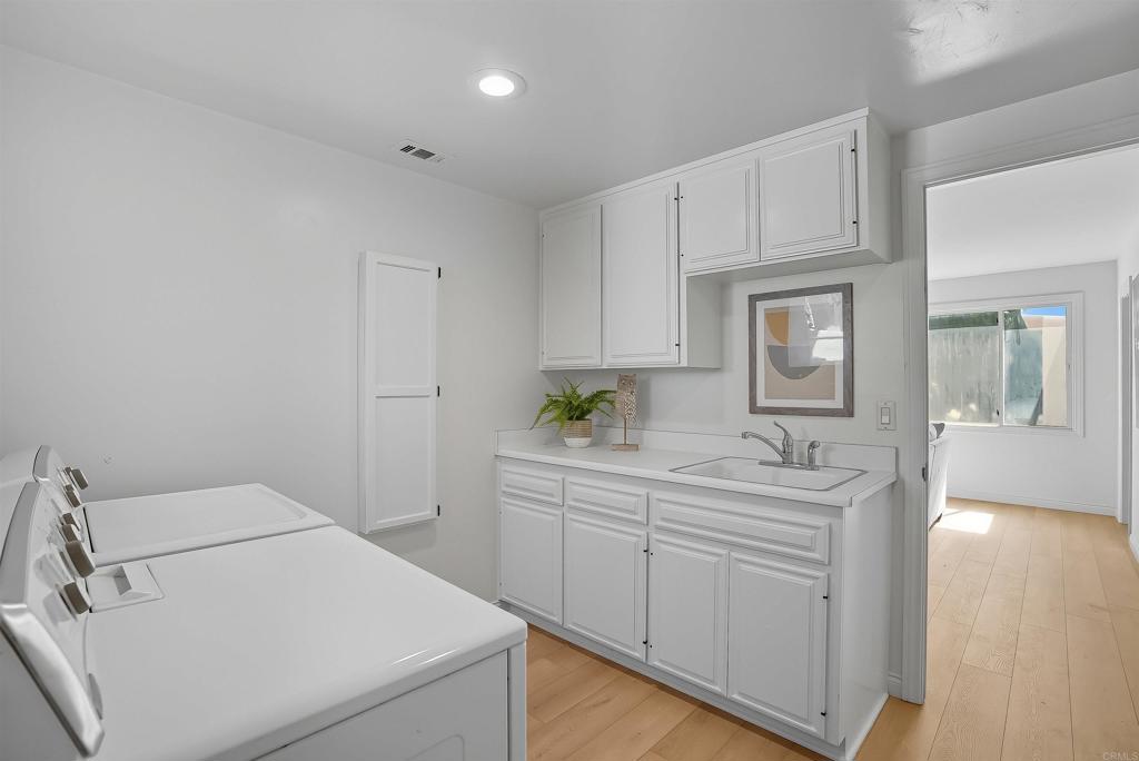 2206 Running Spring Place Encinitas, CA 92024 - Photo 36 of 44 a bathroom with a sink a toilet and cabinets