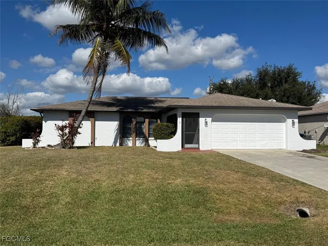 a view of a house with a yard and garage