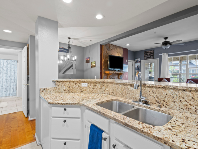 900 Bitner Road, Unit D 34 Park City, UT 84098 - Photo 25 of 25 Kitchen with light stone counters, white cabinets, open floor plan, ceiling fan, and light wood-type flooring