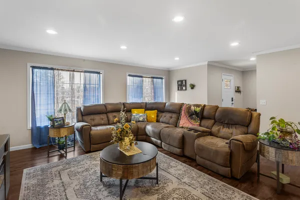 a living room with furniture and a wooden floor