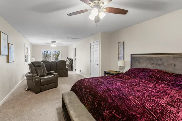 a bedroom with a bed and ceiling fan