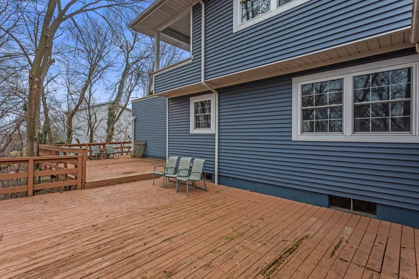 a backyard of a house with wooden fence and large trees