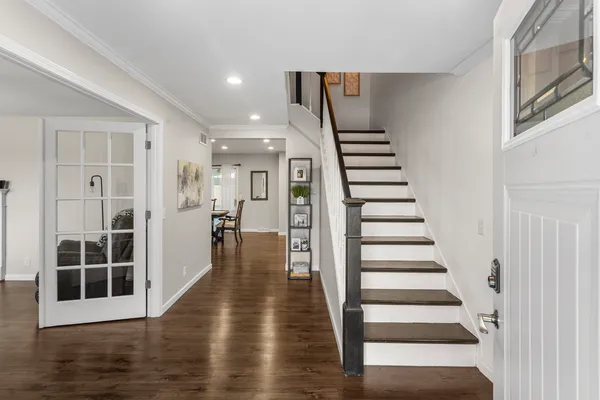 a view of a hallway with wooden floor windows and stairs