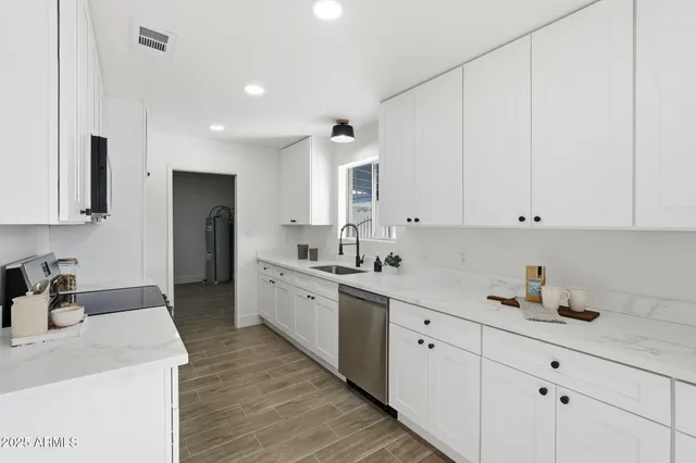 a large white kitchen with stainless steel appliances