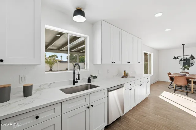 a kitchen with white cabinets sink and refrigerator