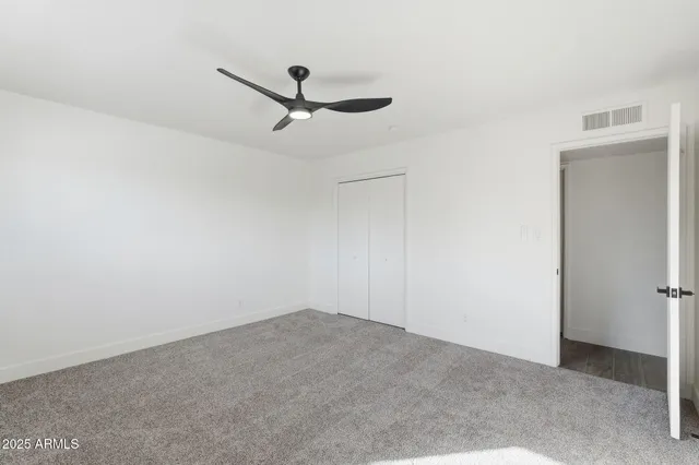 a living room with ceiling fan and window