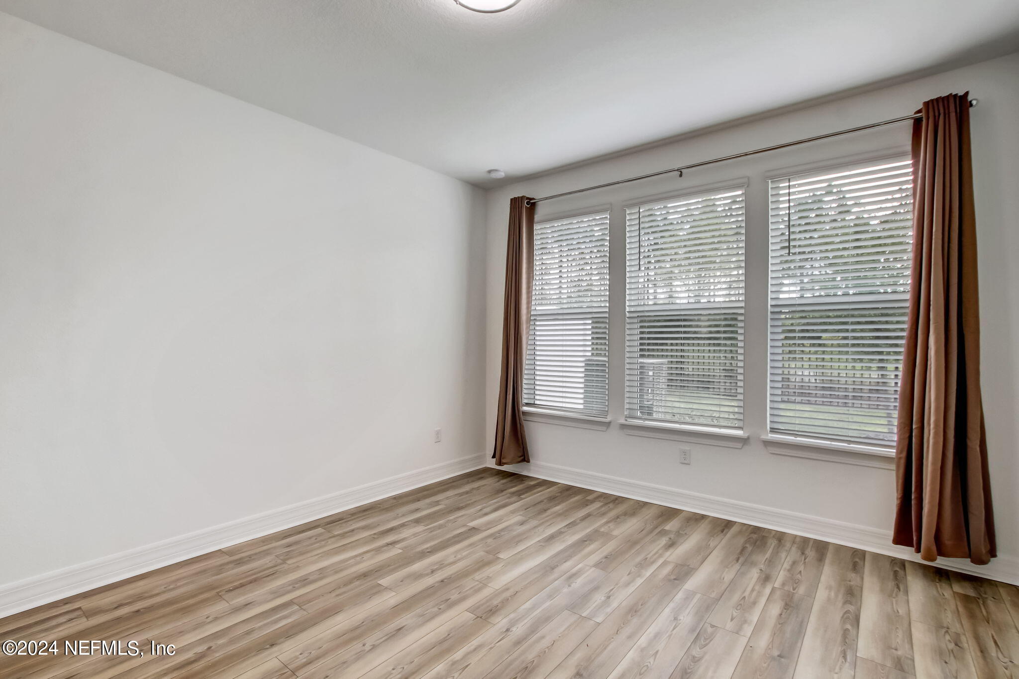 524 Jubilee Circle Yulee, FL 32097 - Photo 10 of 25 a view of an empty room with wooden floor and a window