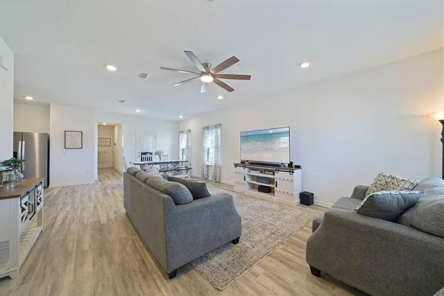 a living room with furniture and a wooden floor