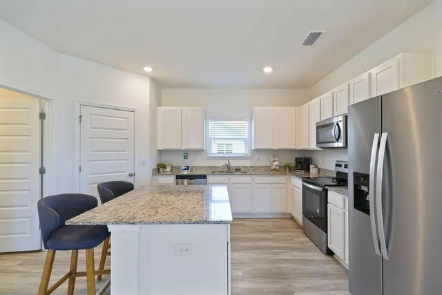 a kitchen with stainless steel appliances granite countertop a refrigerator sink and cabinets