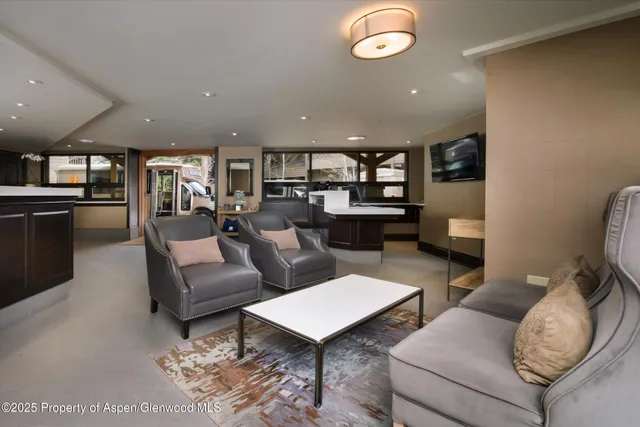 a living room with furniture kitchen view and a large window