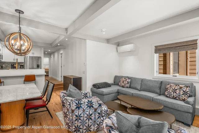 a living room with furniture a rug a lamp and a large window