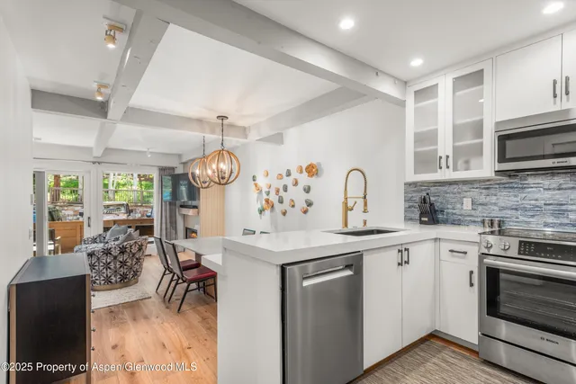 a kitchen with stainless steel appliances granite countertop a sink stove and cabinets