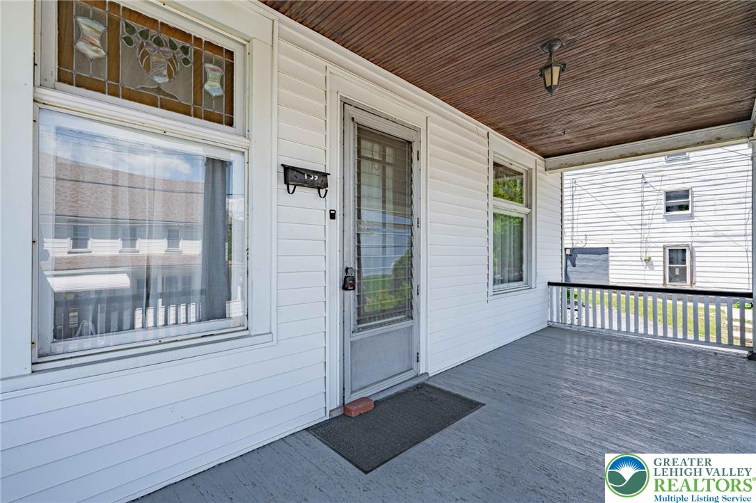 159 West Ridge Street Nesquehoning, PA 18240 - Photo 4 of 55 A welcoming front porch, featuring wood siding and classic railings, offers a serene outdoor retreat.