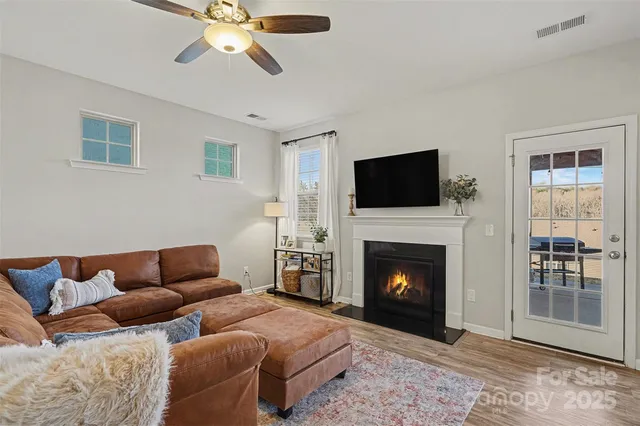 a living room with furniture a fireplace and a flat screen tv
