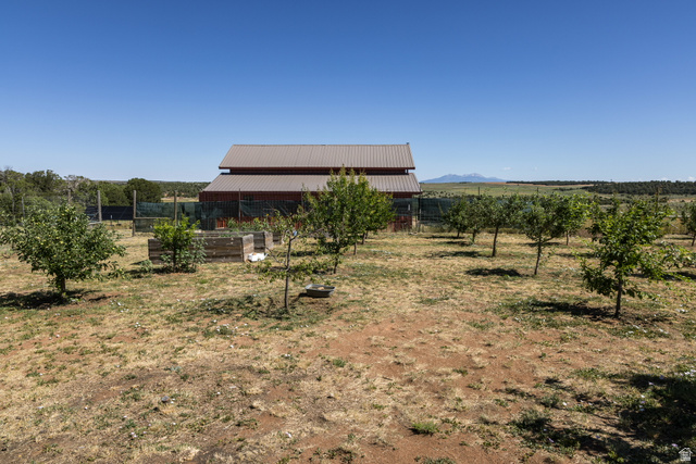 684 Blue Mountain Ridge Monticello, UT 84535 - Photo 26 of 71 View of yard featuring a rural view, an outdoor structure, a vegetable garden, and agricultural plots