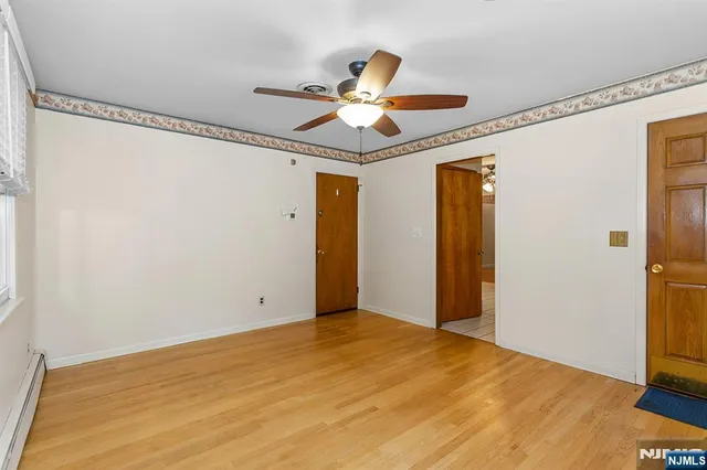 a view of empty room with wooden floor