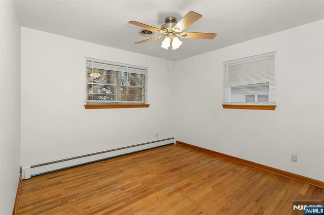 a view of an empty room with a window and a ceiling fan
