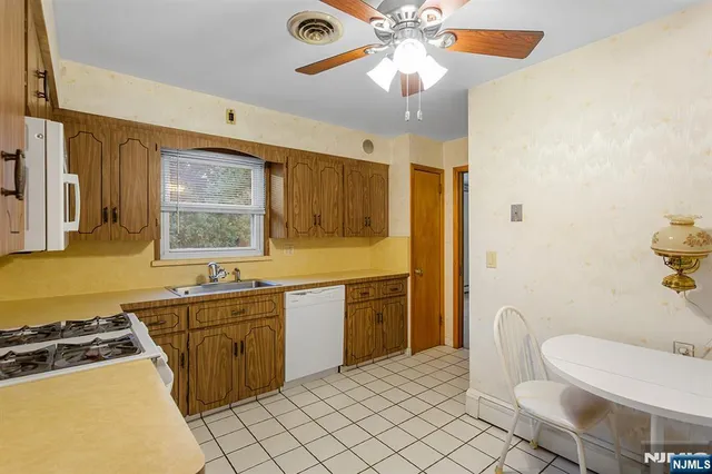 a kitchen with a sink chairs and stove