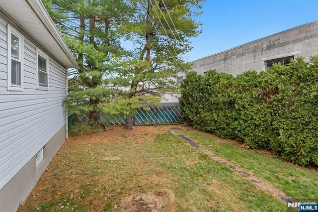 a view of a yard with plants and brick wall