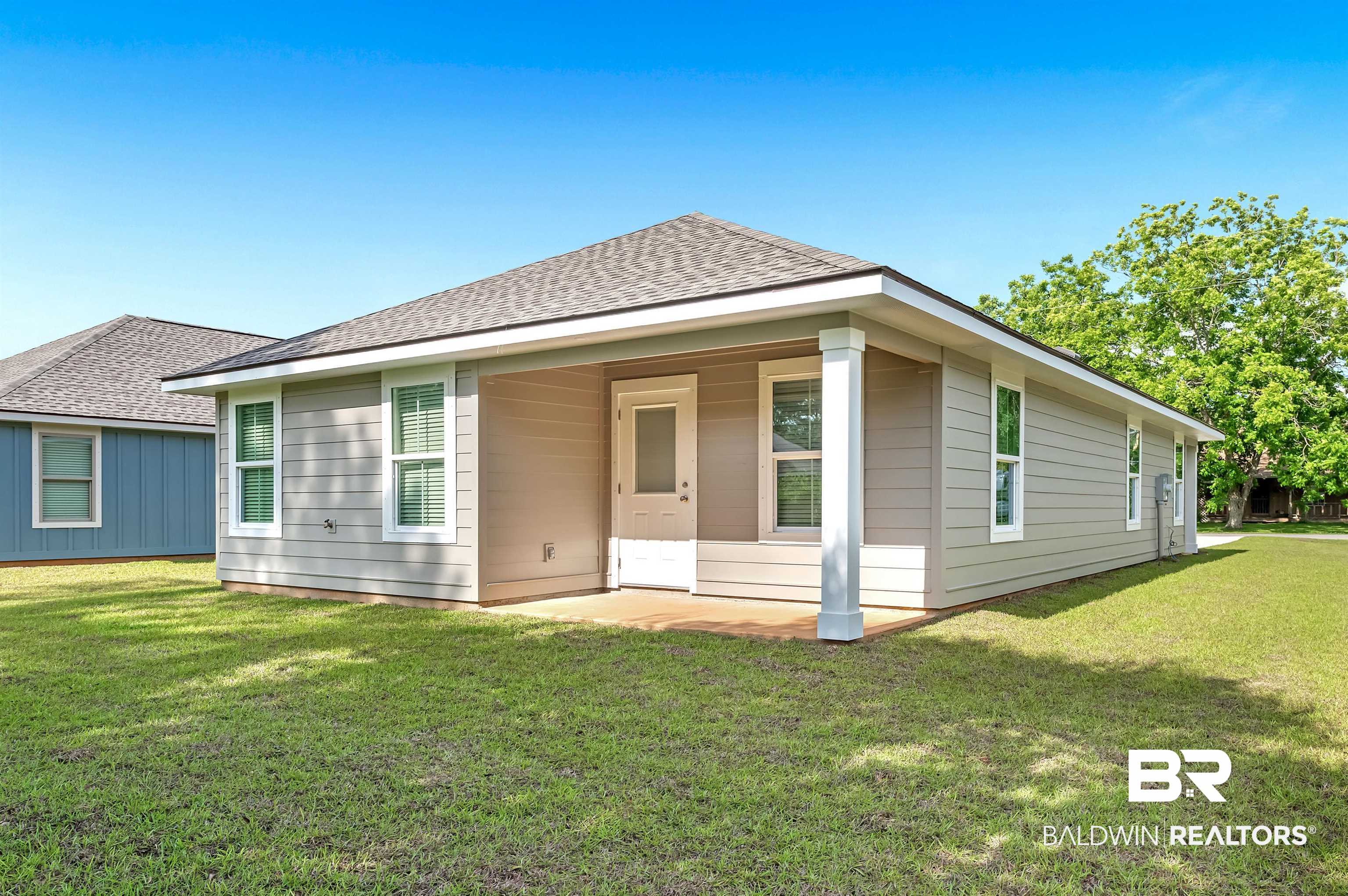 22045 8th Street Silverhill, AL 36576 - Photo 35 of 39 Rear view of property featuring roof with shingles and a lawn