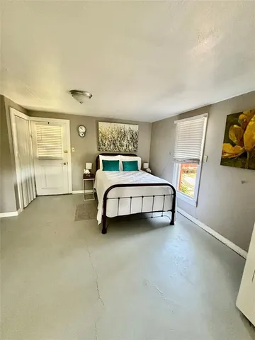 a bedroom with a bed and painting on the wall