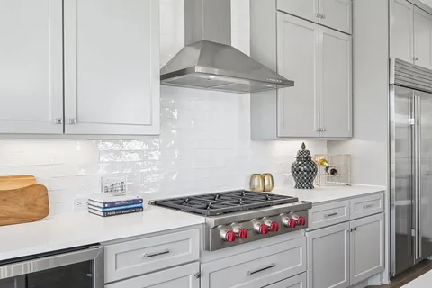 a kitchen with white cabinets and appliances