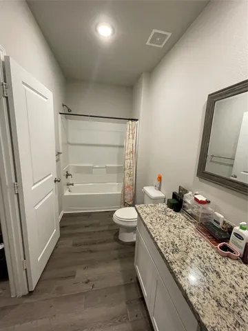 a bathroom with a granite countertop sink toilet and shower
