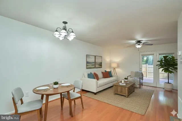 a living room with furniture a chandelier and a wooden floor