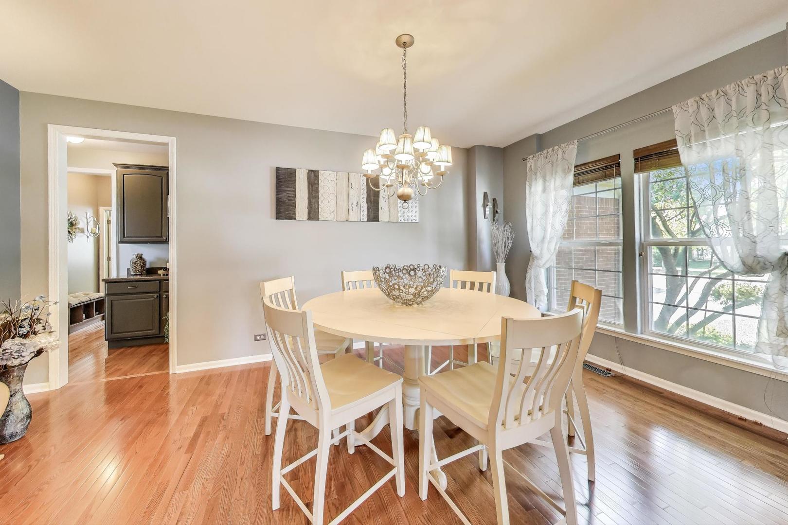 705 Porter Circle Lindenhurst, IL 60046 - Photo 3 of 34 a dining room with furniture a chandelier and wooden floor