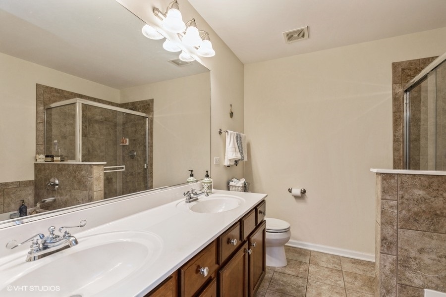 560 Lancaster Drive Pingree Grove, IL 60140 - Photo 12 of 26 a bathroom with a double vanity sink and a mirror